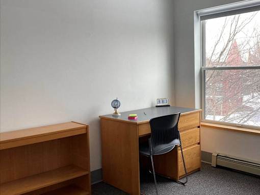a desk and a chair in a room with a window