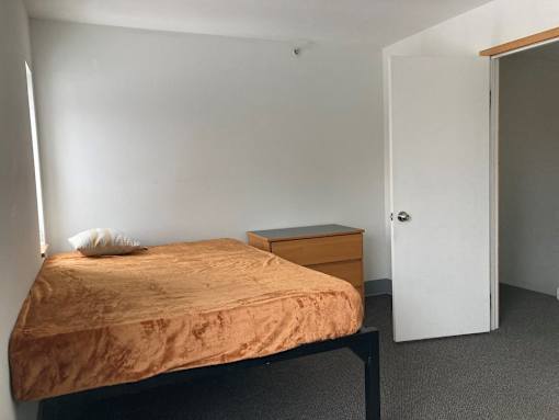a small bedroom with a bed and a dresser