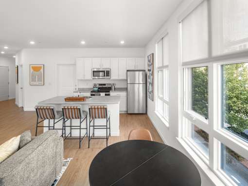 A modern kitchen with a dining table and chairs.