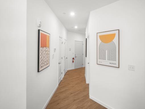 A hallway with two paintings on the wall.