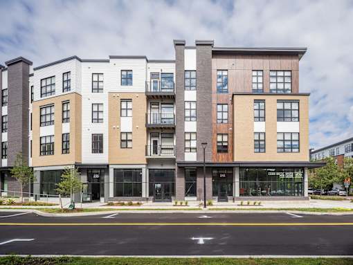 A modern apartment building with a mix of beige and brown facades.