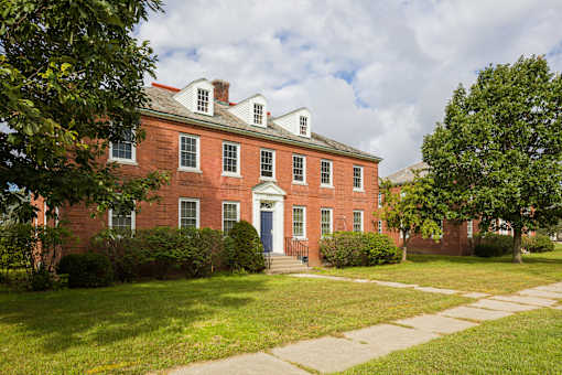 A red brick building with white trim and a white door.