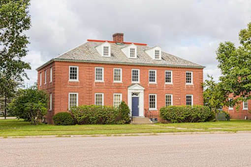 A red brick building with a white door and windows.