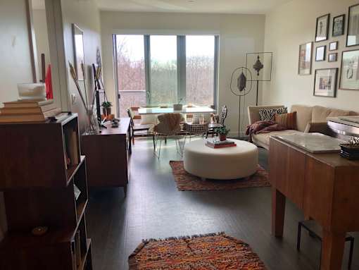 A living room with a couch, a table, and a rug.