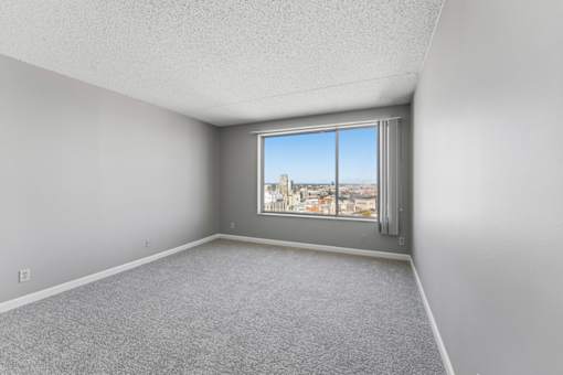 A room with a window overlooking a cityscape.