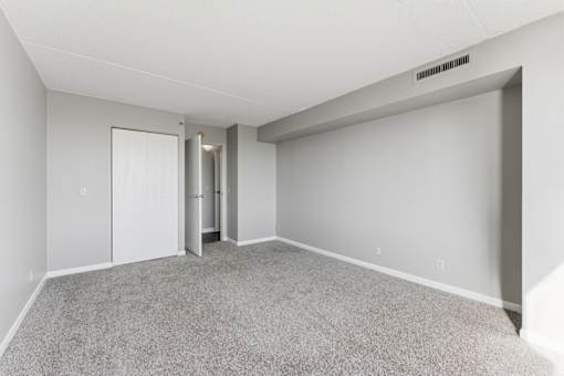 A room with a carpeted floor and a white door.