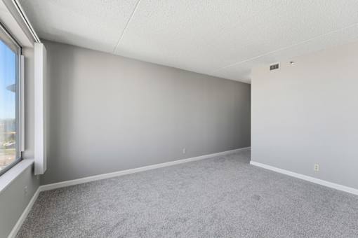 A room with grey carpet and white walls.