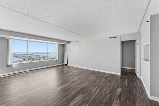 A room with a view of the city through a large window.