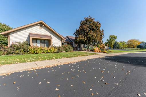 A house with a driveway full of leaves.