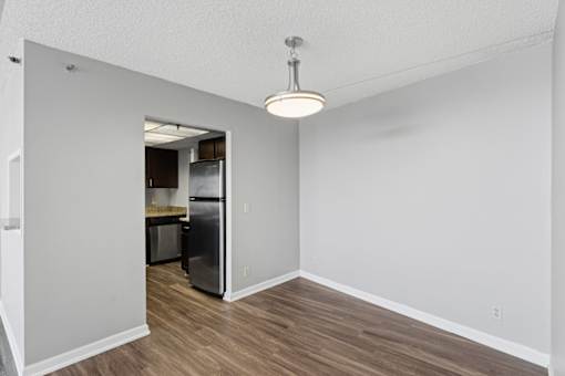 A kitchen area with a refrigerator and a dining table.