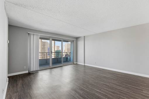 A room with a sliding glass door leading to a balcony.