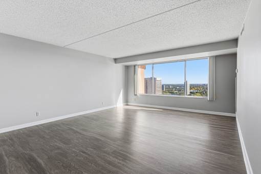 A spacious room with a view of the city through a large window.
