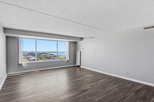 A room with a large window overlooking a cityscape.