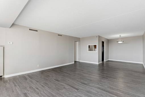 A spacious room with grey flooring and white walls.