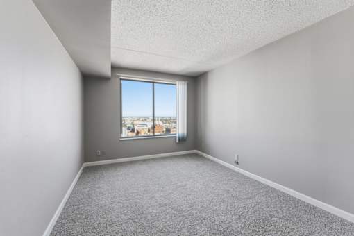 A room with a large window overlooking a cityscape.