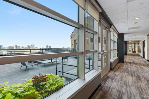 A long hallway with a view of the city outside the windows.