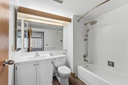 A white bathroom with a toilet, sink, and bathtub.