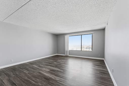 A room with a large window and wooden flooring.