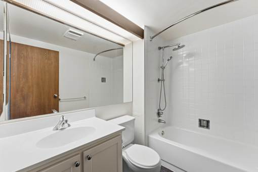 A white bathroom with a toilet, sink, and bathtub.