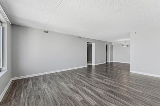 A room with wooden flooring and white walls.