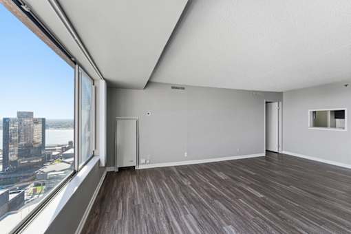 A room with a large window overlooking a cityscape.