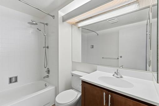 A white bathroom with a toilet, sink, and bathtub.