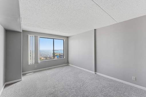 A room with a large window and a view of the city.