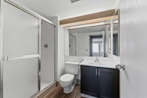 A bathroom with a toilet, sink, and mirror.