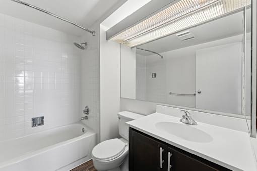 A white bathroom with a toilet, sink, and bathtub.