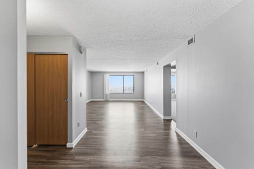 A long hallway with a brown door on the left.