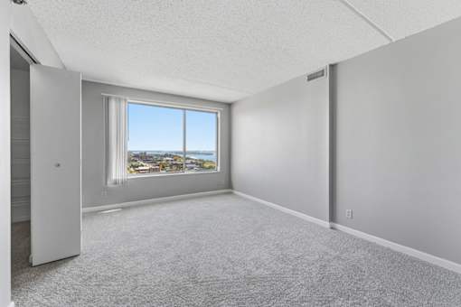 A room with a large window overlooking a cityscape.