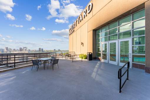 A patio area with a table and chairs outside a building with a sign that says "Fourward".