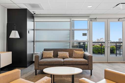 A modern living room with a couch, chairs, and a table.