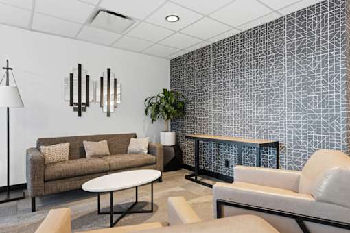 A living room with a couch, a chair, a table, and a lamp.