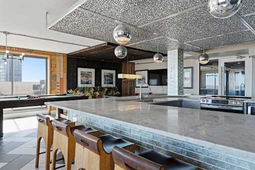 A kitchen with a bar area and wooden chairs.