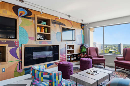 A living room with a colorful mural on the wall and a chess board on the coffee table.