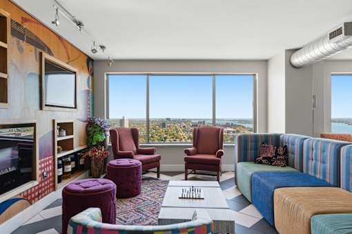 A living room with a large window overlooking a cityscape.