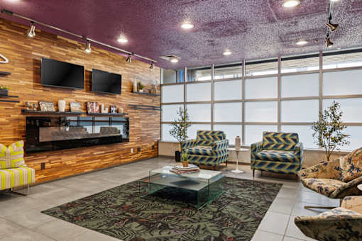 A living room with a fireplace and a glass coffee table.