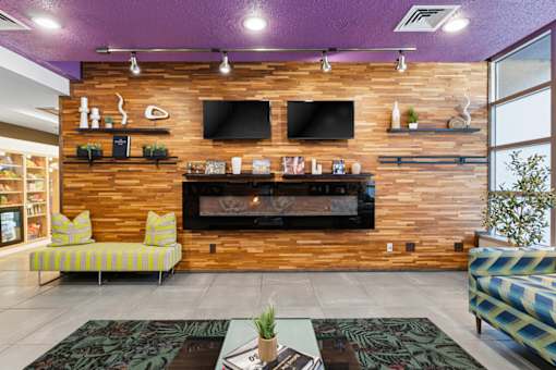 A living room with a fireplace and a flat screen TV mounted on the wall.