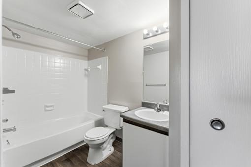 A white bathroom with a toilet, sink, and bathtub.
