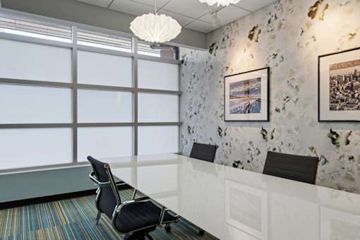 A room with a chair and a wall with pictures.