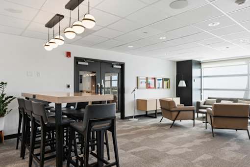 A modern office space with a long table and chairs.