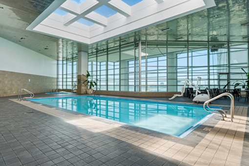A large indoor swimming pool with a skylight above it.