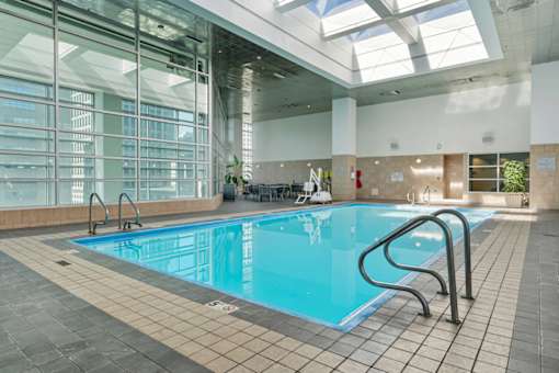 A large indoor swimming pool with a glass wall on one side.