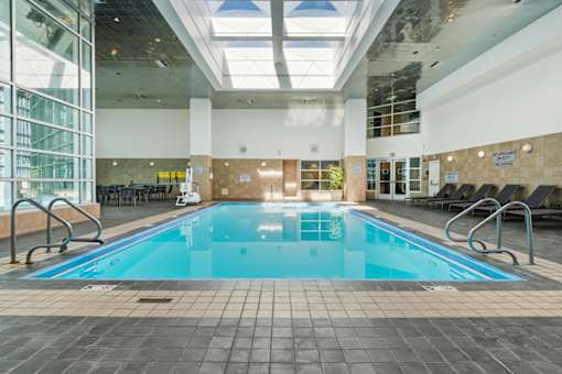 A large indoor swimming pool with a glass ceiling.