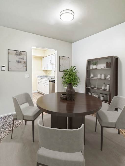 A dining room with a round table and chairs.