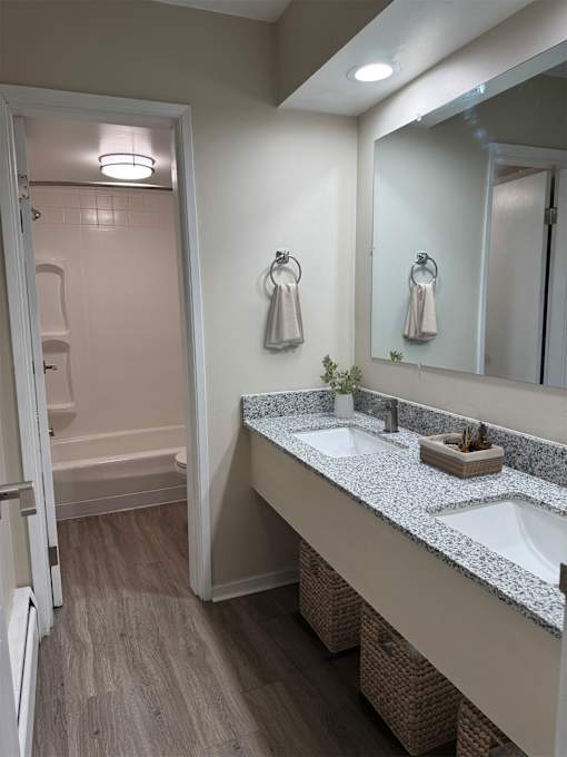 A bathroom with a double sink vanity and a walk-in shower.