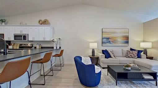 A modern living room area with adjacent breakfast bar.