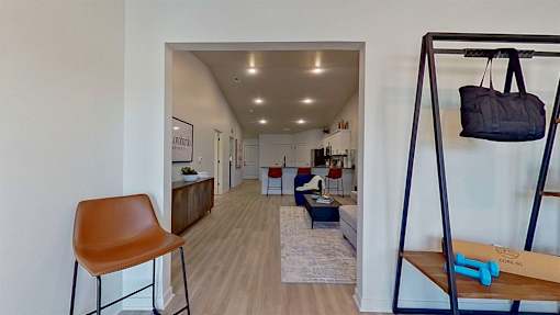 A view of the threshold between the front room and living room area with modern recessed lighting.