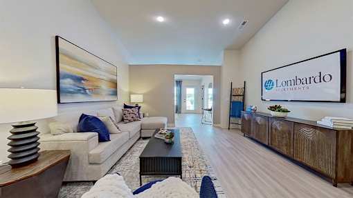 A spacious living room with a couch, coffee table, and a painting on the wall.